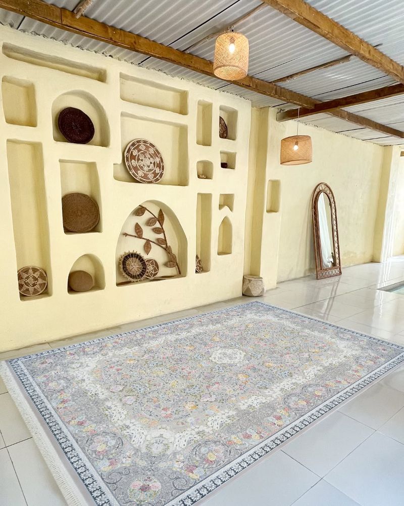 Decorative rug on a tiled floor with a wall featuring decorative plates and shelves.